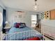 Light blue bedroom featuring white metal frame bed and crib with themed decorations and a whimsical light fixture at 1083 Margate Dr, Greenwood, IN 46143
