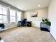 Bright living room featuring neutral walls, carpet, windows with white curtains, and wainscoting at 1083 Margate Dr, Greenwood, IN 46143