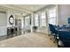 Inviting living area with carpet, wainscoting, large windows, and a glimpse into the home's entrance at 1083 Margate Dr, Greenwood, IN 46143