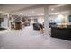 Fully finished basement with a recreation area, bar, seating, and stairway to the upper level at 12991 Pennington Rd, Fishers, IN 46037