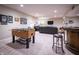Finished basement with a foosball table, bar area, and comfortable seating for entertaining at 12991 Pennington Rd, Fishers, IN 46037