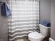 Cozy bathroom with gray walls and a shower featuring a gray striped curtain and a neatly folded towel at 12991 Pennington Rd, Fishers, IN 46037