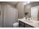 Well-lit bathroom with a vanity, mirror, and a patterned shower curtain for a clean and functional space at 12991 Pennington Rd, Fishers, IN 46037