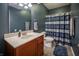 Clean bathroom showcasing a wood vanity, large mirror, and a shower with a blue striped curtain at 12991 Pennington Rd, Fishers, IN 46037
