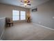 Bright bonus room features neutral walls, plush carpeting, ceiling fan, and natural light from windows at 12991 Pennington Rd, Fishers, IN 46037