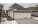 Side view showcasing the home's two-car garage with ample driveway space and snow-dusted lawn at 12991 Pennington Rd, Fishers, IN 46037