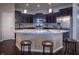 Modern kitchen with dark cabinets, stainless steel appliances, an island with granite countertops, and barstool seating at 12991 Pennington Rd, Fishers, IN 46037