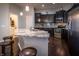 Modern kitchen featuring dark cabinets, stainless steel appliances, an island with granite countertops, and barstool seating at 12991 Pennington Rd, Fishers, IN 46037