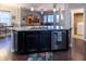 Open kitchen with stainless appliances, black cabinets, and an island with a granite countertop at 12991 Pennington Rd, Fishers, IN 46037