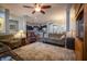 Open concept living room with hardwood floors, ceiling fan, adjacent kitchen and dining area, and comfortable seating at 12991 Pennington Rd, Fishers, IN 46037