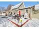 Backyard patio with outdoor furniture, and a red door, covered in a fresh blanket of snow at 1390 Greenfield Ave, Noblesville, IN 46060