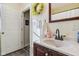 Well-lit bathroom with a wood vanity, decorative mirror, and convenient access to an adjacent space at 1390 Greenfield Ave, Noblesville, IN 46060