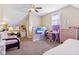 Comfortable bedroom featuring a ceiling fan, desk, and colorful accent wall at 1390 Greenfield Ave, Noblesville, IN 46060