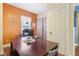 Dining room with a large table, natural light, and orange accent wall at 1390 Greenfield Ave, Noblesville, IN 46060