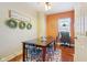 Bright dining area featuring wood floors, a wooden table set, and views of the backyard at 1390 Greenfield Ave, Noblesville, IN 46060