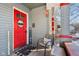Cozy front porch featuring a red door, welcome sign, chair, and decorative touches, inviting relaxation at 1390 Greenfield Ave, Noblesville, IN 46060