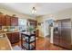 Bright kitchen featuring stainless steel appliances, brown cabinetry, and a mobile prep island at 1390 Greenfield Ave, Noblesville, IN 46060