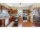 Well-lit kitchen with stainless steel appliances, wooden cabinets, and hardwood floors at 1390 Greenfield Ave, Noblesville, IN 46060