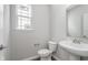 Bright powder room features a pedestal sink, toilet, and window at 14390 Bishop Birch Pl, Carmel, IN 46032