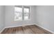 Empty bedroom with wood flooring, double windows, and neutral paint at 14390 Bishop Birch Pl, Carmel, IN 46032