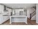 Bright, open kitchen featuring white cabinets, stainless appliances, and a large island at 14390 Bishop Birch Pl, Carmel, IN 46032