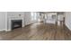 Open-concept living area showing luxury vinyl flooring, a fireplace, and a peek into the kitchen at 14390 Bishop Birch Pl, Carmel, IN 46032
