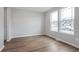 Bright, airy living room featuring wood floors and large windows showcasing the neighborhood at 14390 Bishop Birch Pl, Carmel, IN 46032
