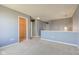 Open living room with neutral carpet, half wall, and a hallway with closet at 15486 Dusty Trl, Noblesville, IN 46060