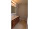 Bathroom with a double vanity, wood cabinets, and ceramic tile flooring at 1588 E Us Highway 136, Hillsboro, IN 47949