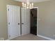 Bedroom with a hanging light fixture, two doors, and carpeted floors at 1588 E Us Highway 136, Hillsboro, IN 47949