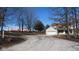 View of charming home with a gravel driveway leading to a spacious two-car garage and a large barn at 1588 E Us Highway 136, Hillsboro, IN 47949