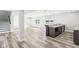 Open basement bar with granite countertop, dark wood cabinets, modern pendant lights and luxury vinyl flooring at 15969 Sonnet Park Ln, Westfield, IN 46074