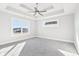 Inviting bedroom featuring a tray ceiling, a ceiling fan, plush carpet, and bright windows for natural light at 15969 Sonnet Park Ln, Westfield, IN 46074