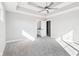 Relaxing bedroom with a ceiling fan, tray ceiling, plush carpet, and an ensuite bathroom for added convenience at 15969 Sonnet Park Ln, Westfield, IN 46074