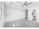 Spacious bedroom featuring plush gray carpet, a ceiling fan, and an ensuite bathroom with modern fixtures at 15969 Sonnet Park Ln, Westfield, IN 46074