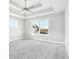 Bright bedroom with a ceiling fan, tray ceiling, plush carpet, and a large window offering a view of the neighborhood at 15969 Sonnet Park Ln, Westfield, IN 46074