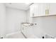 Well-lit laundry room with white cabinets, granite countertop and gold hardware at 15969 Sonnet Park Ln, Westfield, IN 46074