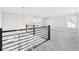 Open loft space with neutral carpet, sleek metal railings, and natural light from windows at 15969 Sonnet Park Ln, Westfield, IN 46074