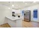 Well-lit kitchen with stainless steel appliances, white cabinets, quartz countertops, and kitchen island at 19487 Grassy Branch Rd, Westfield, IN 46074