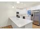 Well-lit kitchen with stainless steel appliances, white cabinets, quartz countertops, and kitchen island at 19487 Grassy Branch Rd, Westfield, IN 46074