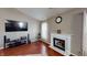 Cozy living room with hardwood floors, fireplace, and a large television for entertainment at 2228 Silver Rose Dr, Avon, IN 46123