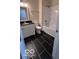 Bright bathroom featuring black tile floor, toilet, white tub and shower combination, and vanity with black countertop at 229 Hillendale Dr, Greenwood, IN 46142