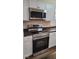 Modern kitchen features stainless steel stove with overhead microwave, white cabinets, and dark countertops at 229 Hillendale Dr, Greenwood, IN 46142