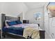 Bright bedroom features a cozy queen bed with navy blue bedding and a view from the window at 234 N State Ave, Indianapolis, IN 46201