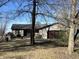 Single story home with attached garage, covered porch, mature trees, and wood siding at 338 A St, Wilkinson, IN 46186