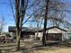 Single story home with attached garage, covered porch, mature trees, and wood siding at 338 A St, Wilkinson, IN 46186