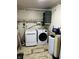 This laundry room has a washing machine, dryer, shelving, and a water conditioning system at 338 A St, Wilkinson, IN 46186