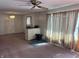 Spacious room featuring a ceiling fan, pink carpet, and light-filled window at 338 A St, Wilkinson, IN 46186