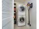 Functional laundry room with stackable washer/dryer and storage shelves at 355 E Ohio St # 116, Indianapolis, IN 46204