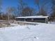 Exterior view of a house with a large snow-covered backyard with bare trees at 401 W Edwards Ave, Indianapolis, IN 46217